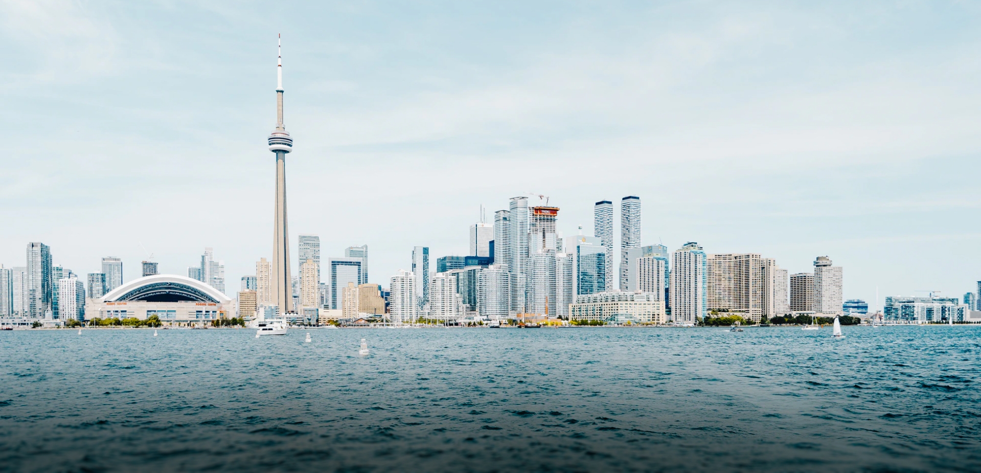 Images of Toronto's skyline on a sunny day, with a body of water in the foreground.